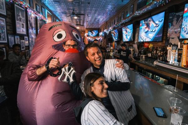 Post reporter David Propper dons a Grimace outfit while posing with Yankee fans in the Bronx on Oct. 17, 2024.